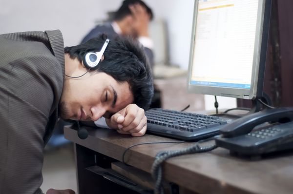 Man sleeping on cubicle desk