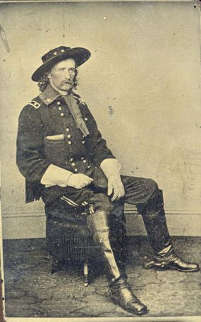 George A. Custer in Military Dress Wearing Hat and Gloves Seated on an Ottoman," circa 1864.