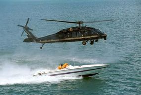 U.S. Customs agents in a Blackhawk helicopter hover over a smuggler's boat. The immense downward air pressure generated by the helicopter's propellers convinces the smugglers to stop where they are.