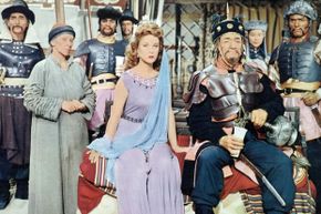 Susan Hayward, John Wayne and assorted other actors in "The Conqueror"”border=