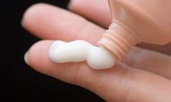 Cream on womans hands.