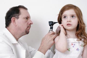 Doctor examining patient's ear with otoscope for healthcare.