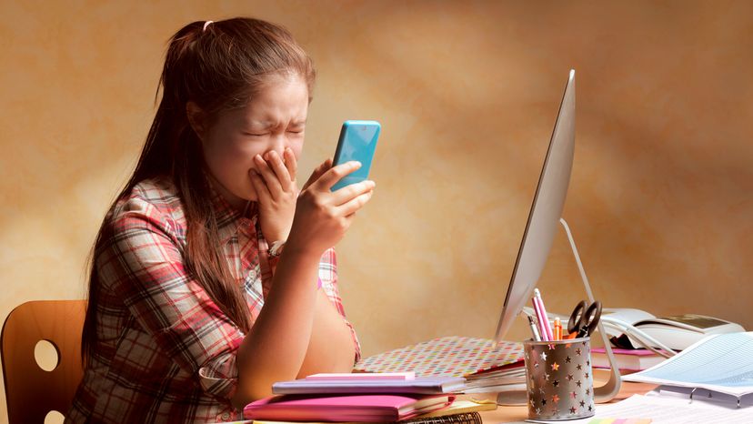 A teenager being bullied on smart phone.