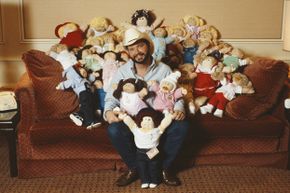 Cabbage Patch Doll creator Xavier Roberts sits amongst a group of Cabbage Patch Kids in 1983.