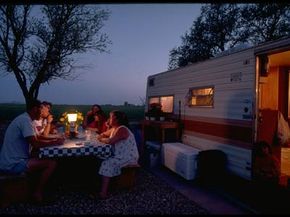 A family enjoys dinner outside their camper at the Antelope Valley RV Park.