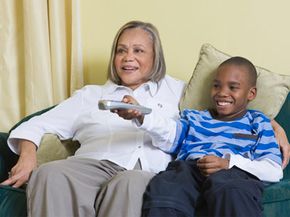grandmother and grandson watch television together