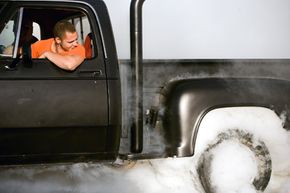 Kevin "Bud" Grimm watches the smoke billow from the rear tires of his 1971 Dodge during the burnout session at the River City Rod Run in Post Falls, Idaho. Grimm blew out both of his rear tires during the burnout.”border=