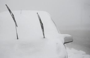 清除任何雪上方和下方你的挡风玻璃刮水器——雪的重量会损坏雨刷机制,使冬季开车危险。”border=