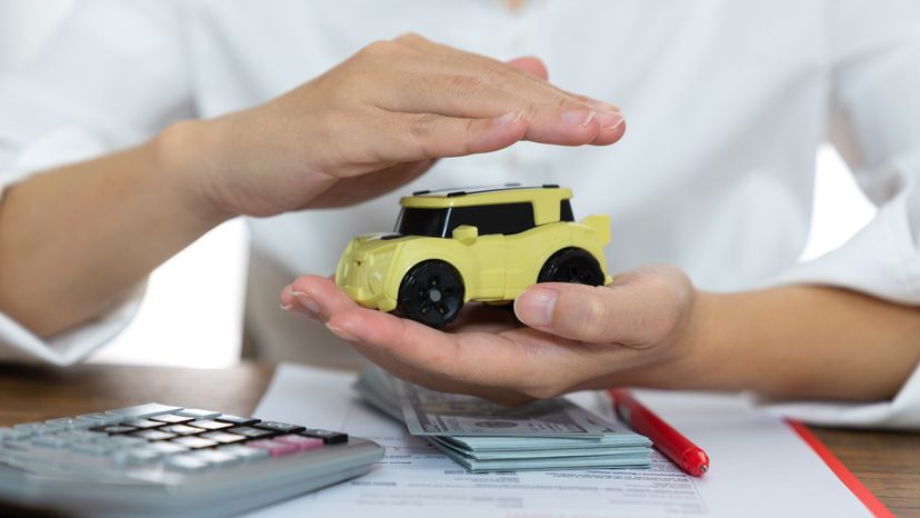 A man holding and protecting a toy car.