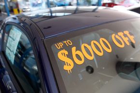 The discount available is written on the windshield of an unsold vehicle at a Ford dealership in east Denver.