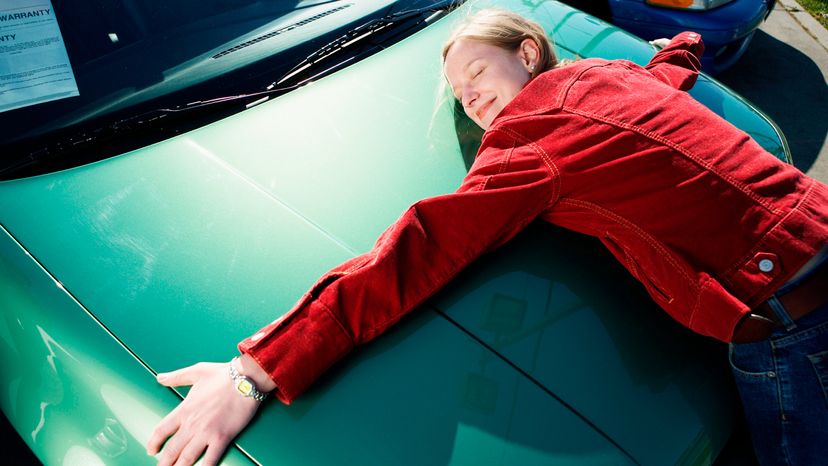 A woman hugging a car