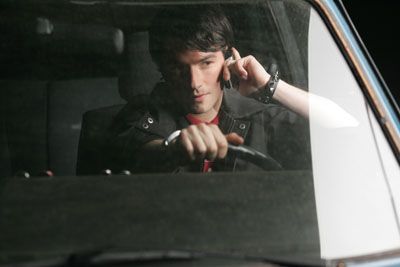 A man talks on a mobile phone while driving in traffic.