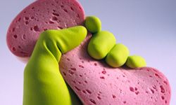 Gloved hand squeezing sponge. 