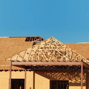 Carport and new home under construction.