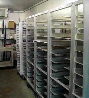The shelving in this walk-in refrigerator can be used to store trays of prepared food.