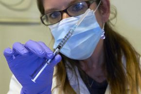 A nurse holds a syringe containing an experimental Ebola virus vaccine during a media visit at Switzerland's Lausanne University Hospital on Nov. 4, 2014.