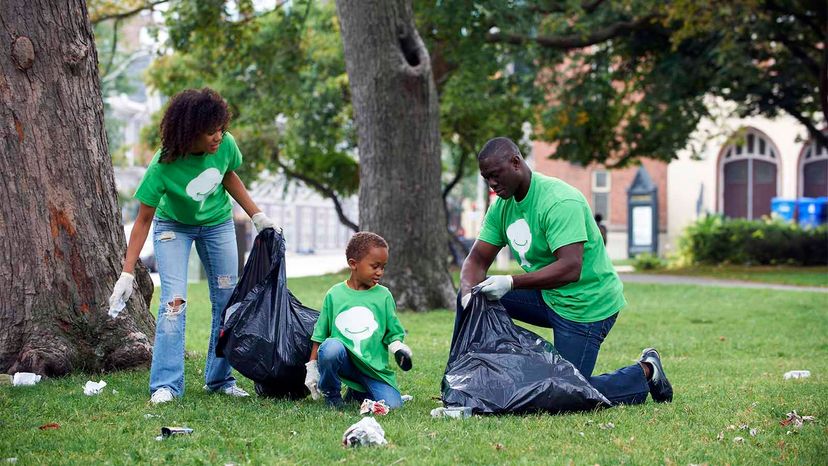 family cleaning up trash in park