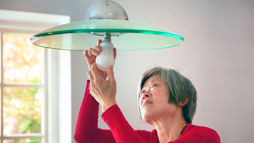 woman replacing light bulb