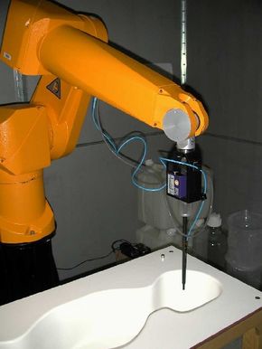 A probe attached to a mechanical arm is directed to take SAR measurements throughout a human-shaped mold. The mold is filled with a liquid mixture that simulates the electrical properties of human tissue.