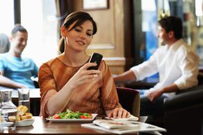 A woman checks messages on her mobile phone. Cell phones have truly taken over the world. See cell phone pictures.