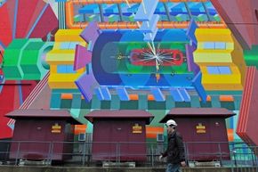 A CERN worker cruises past a painted representation of the LHC’s ATLAS experiment on Dec. 13, 2011, in Geneva, Switzerland.