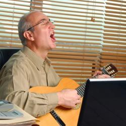 man singing and playing guitar in office