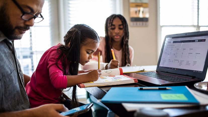 man at computer with daughters