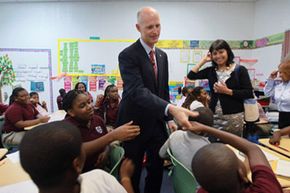 佛罗里达州州长里克·斯科特（Rick Scott）于2011年1月6日访问OPA Locka的佛罗里达国际学院特许学校。“width=