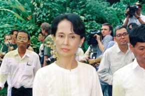In a photo circa 1989, Aung San Suu Kyi walks inside her house on in Yangon, Myanmar surrounded by supporters.