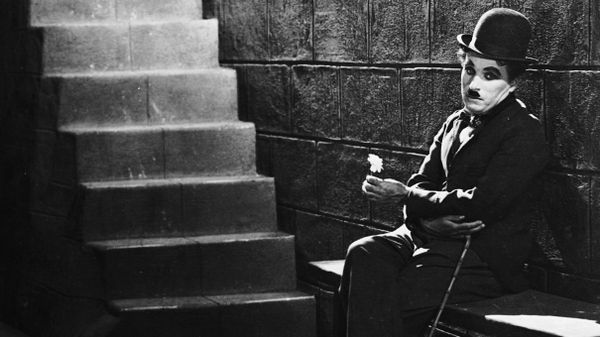 charlie chaplin sits forlorn at the bottom of stairs