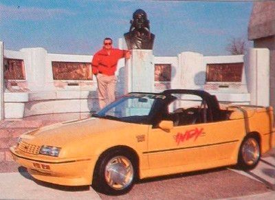 A yellow, 1990 Chevrolet Beretta.
