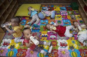 Chinese children drink milk from bottles in a foster home.