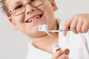 preteen boy with toothbrush and toothpaste