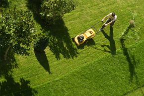 man with push-behind lawn mower
