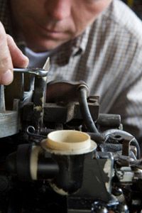 man repairing lawn mower engine