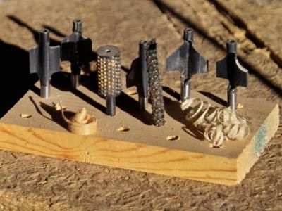 Various router bits in block of wood.