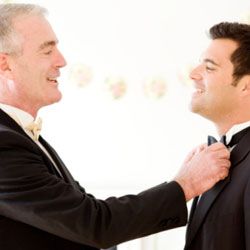 father straightening groom's tie
