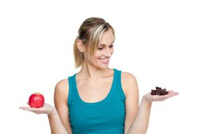 Woman deciding between chocolate and fruit