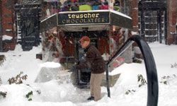 一名波士顿男子将Teuscher巧克力店从雪地里铲了出来。