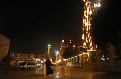 A priest walks at the Mangar square where a Christmas tree is decorated and lighted by the representative of the Palestinian Authority and the Mayor of Bethlehem in December 2005 in the southern town of Bethlehem. 