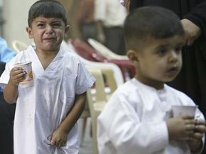An Iraqi child cries as he stands in line to be circumcised July 14, 2005 in Baghdad.