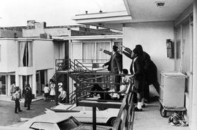 Civil rights leader Andrew Young and others standing on balcony of the Lorraine Motel in Memphis, Tenn., pointing in the direction of the assailant after the assassination of civil rights leader Martin Luther King Jr., who is lying at their feet.