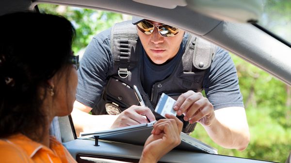 police officer leans into vehicle after traffic stop