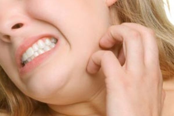 Girl scratching neck.