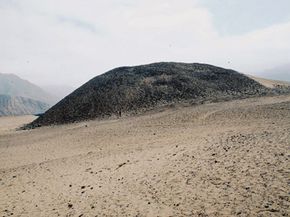 A pyramid at Caral, Peru, is shown buried under a layer of windblown sand and collapsed rock.