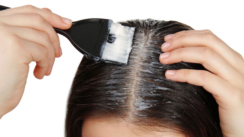 girl applying coconut oil to scalp