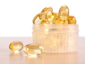 Cod liver oil capsules on a wooden table.