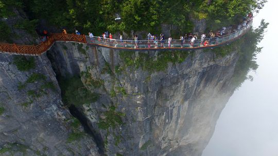 盘龙悬崖空中步道紧贴着玻璃条上的一座山＂border=