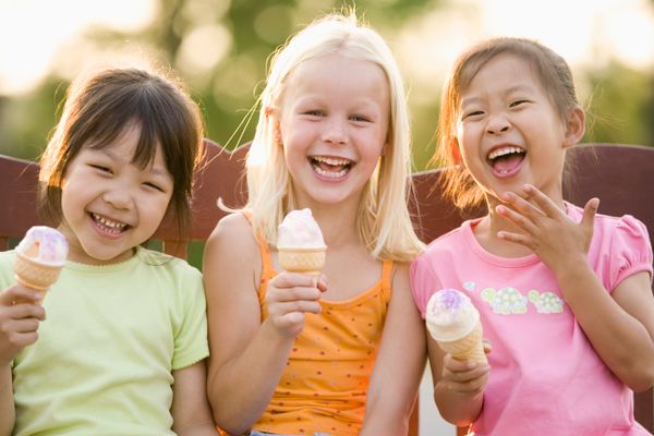 Three kids eat ice cream.