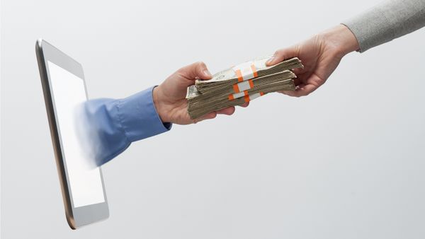 Woman's hand, handing employee compensation money to mans hand coming from digital tablet